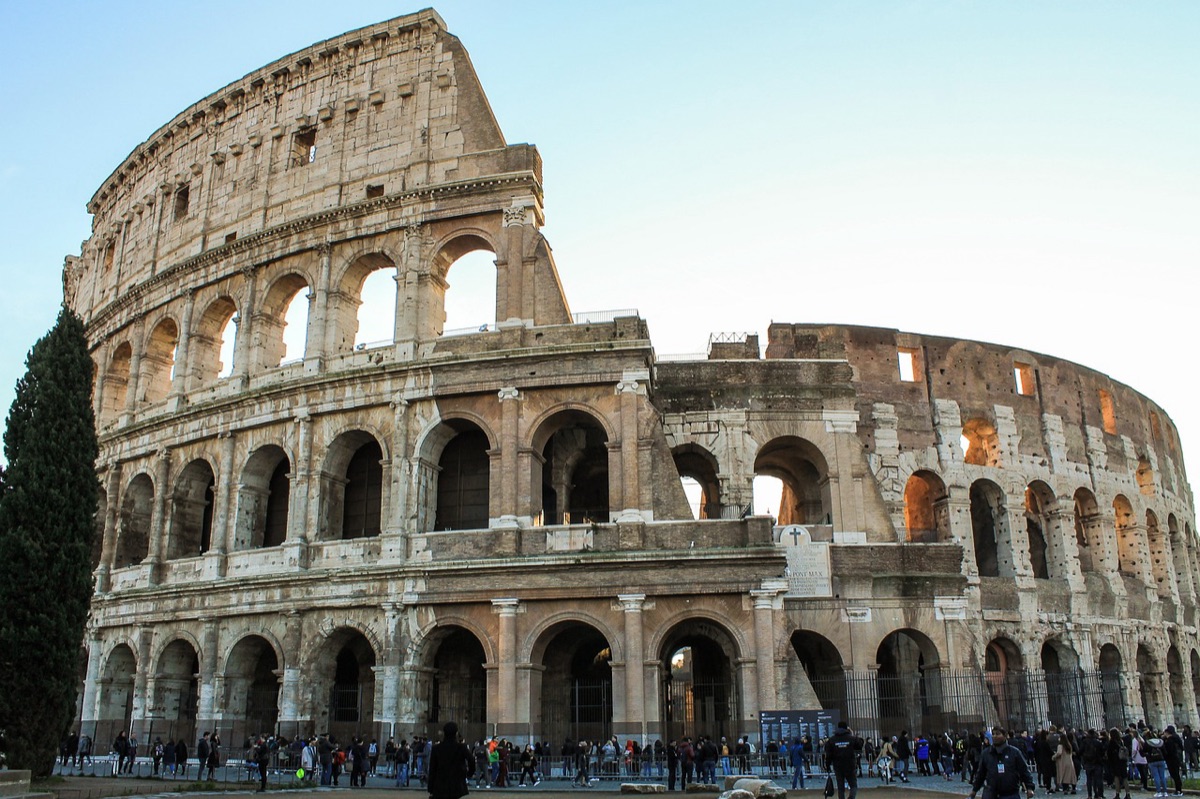 Un visitatore all'ingresso del Colosseo a Roma, con luce naturale e un'atmosfera moody.