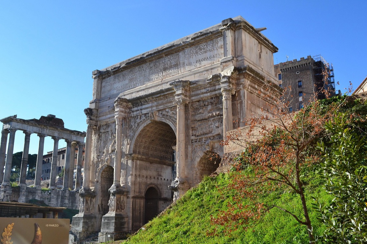 Crowd of people in period costumes at a roman forum